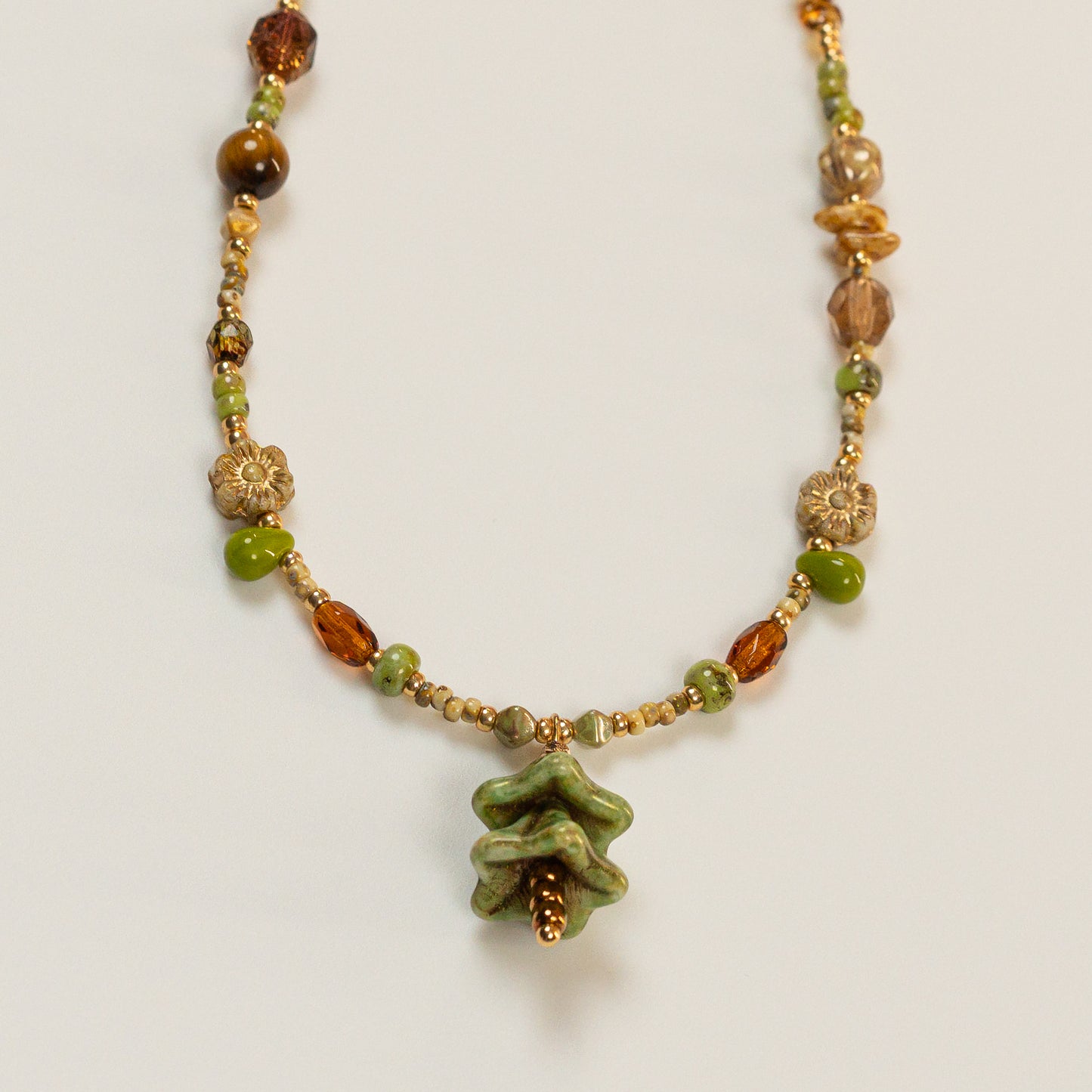 Kralenketting met denvormige hoofdkraal en tijgeroog