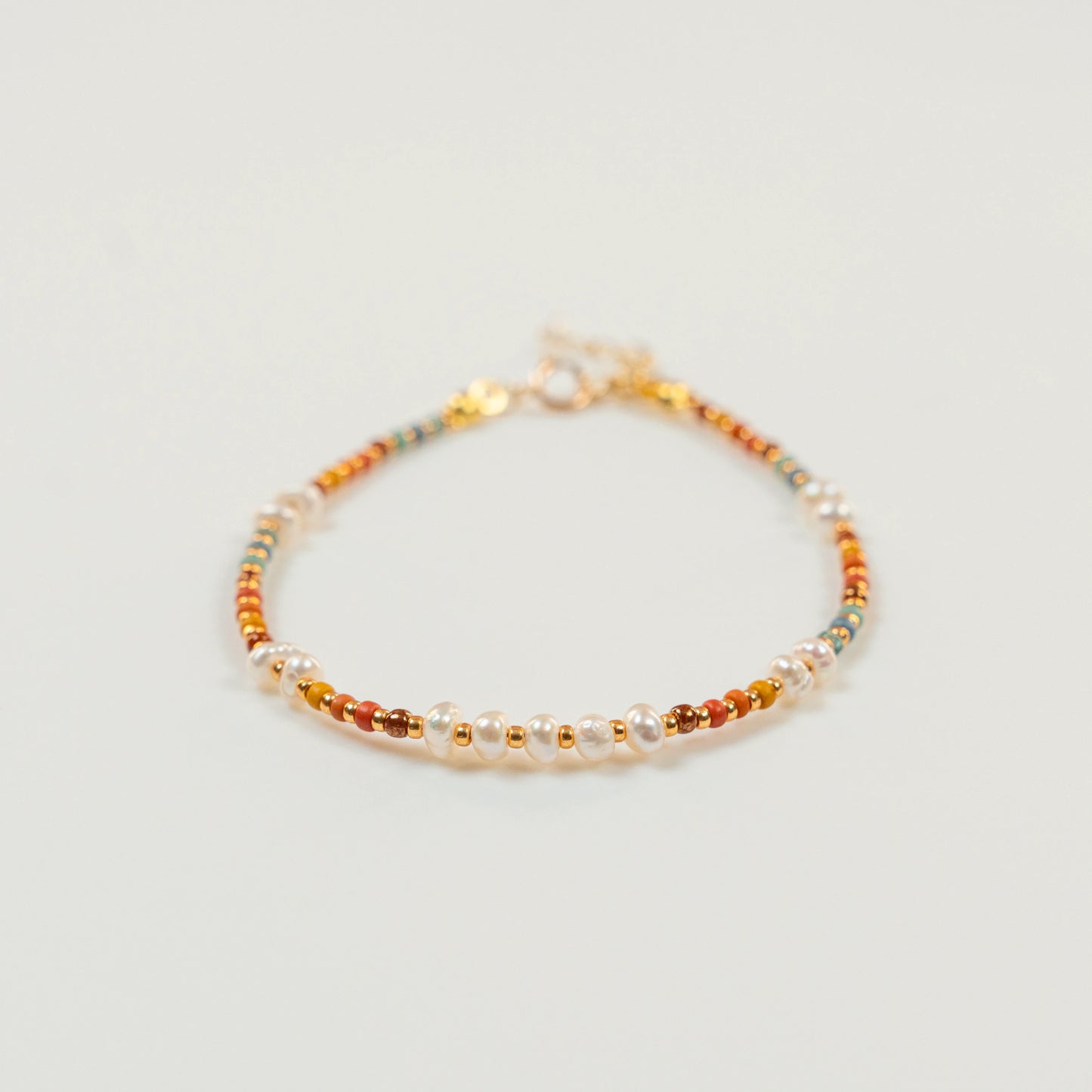 Kralenarmband met regenboogkleurige kralen en parels