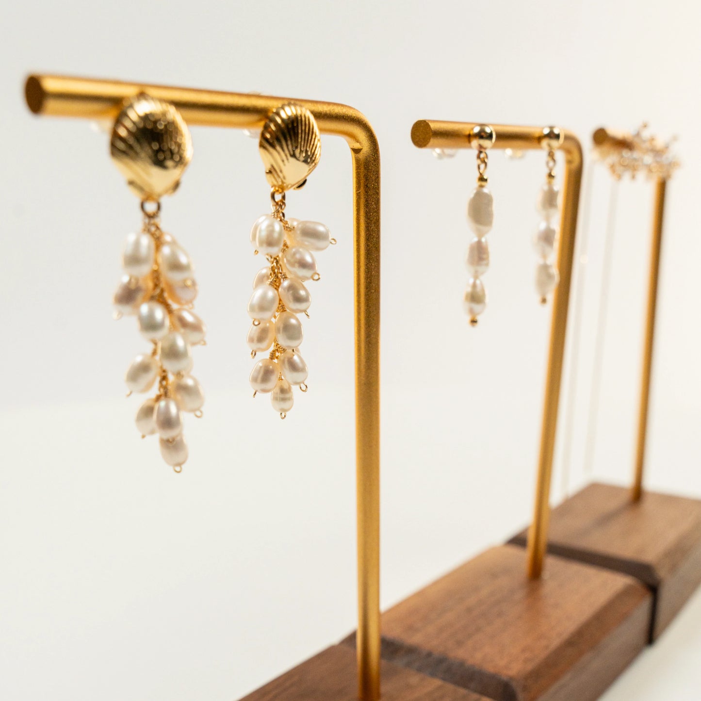 Parel oorbellen met schelpvormige hanger en draadwikkeldesign