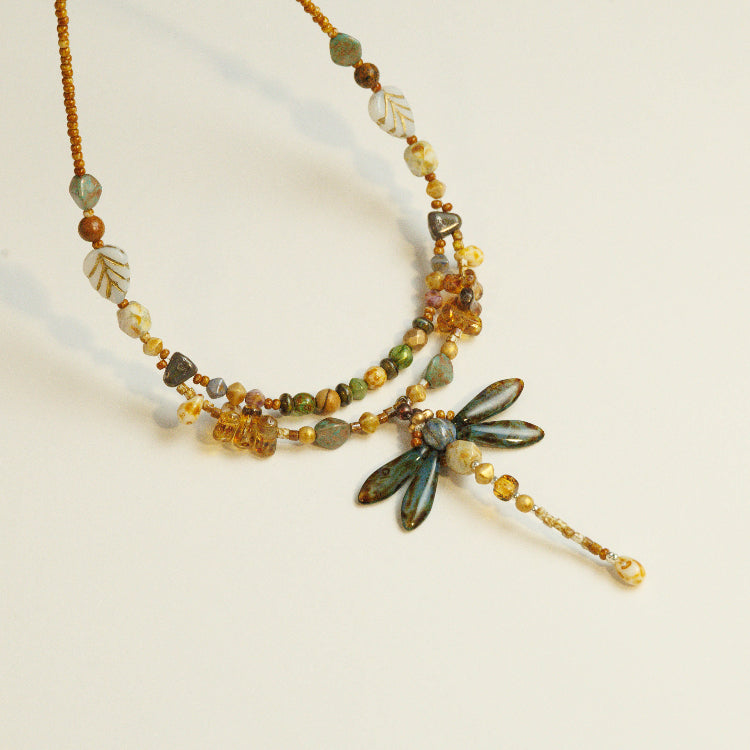 Handgemaakte libelle kralen ketting met kralenweeftechniek, aardetinten en gouden accenten in dubbelgelaagd ontwerp