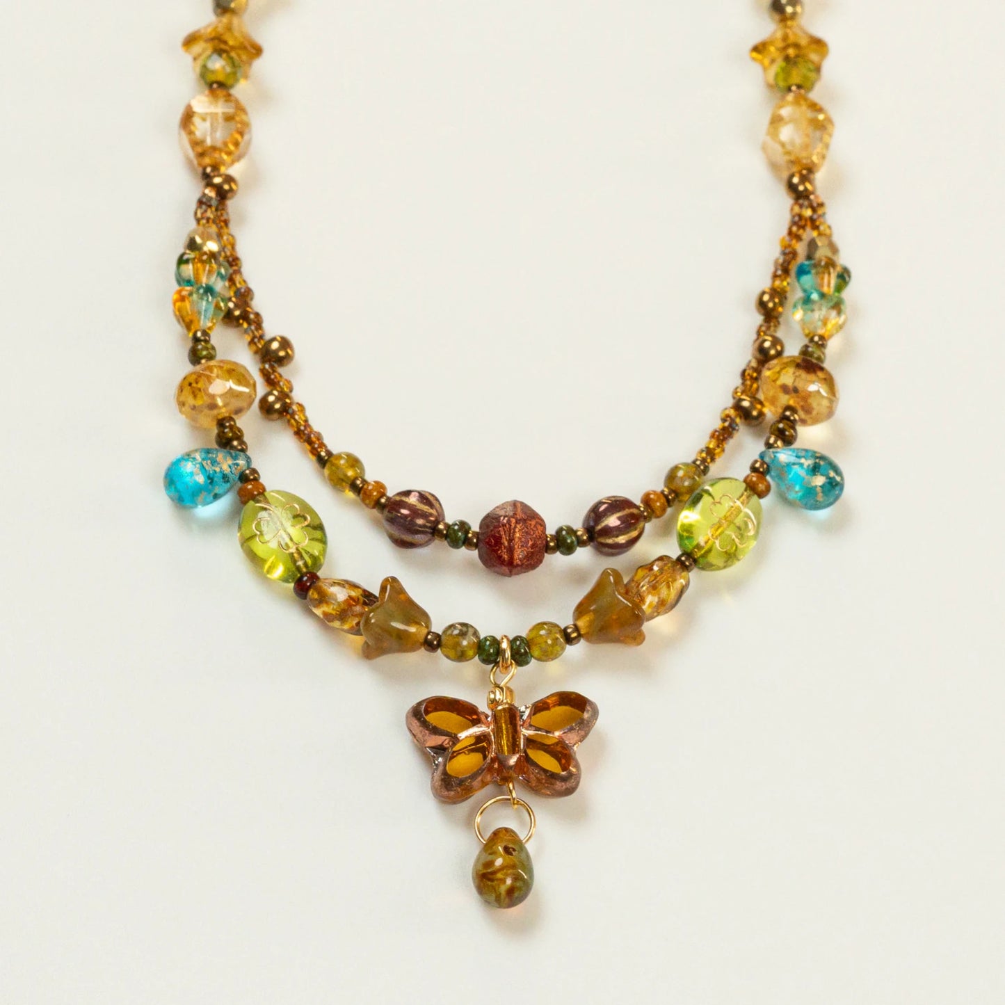 Dubbele kralenketting met amberkleurige vlindervormige