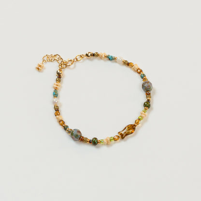 Kralenarmband met visvormige hoofdkraal en parelmoer