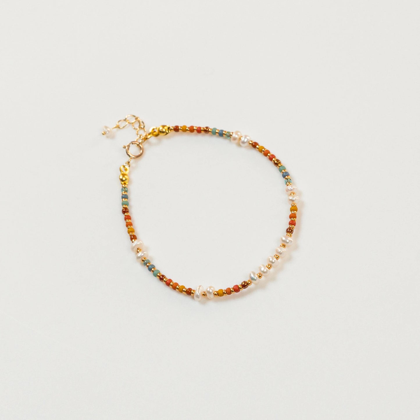 Kralenarmband met regenboogkleurige kralen en parels