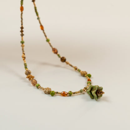 Kralenketting met denvormige hoofdkraal en tijgeroog