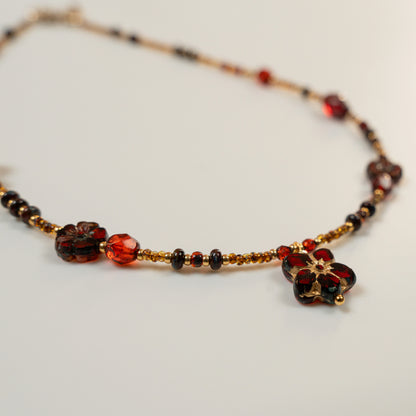 Kralenketting met rode bloem