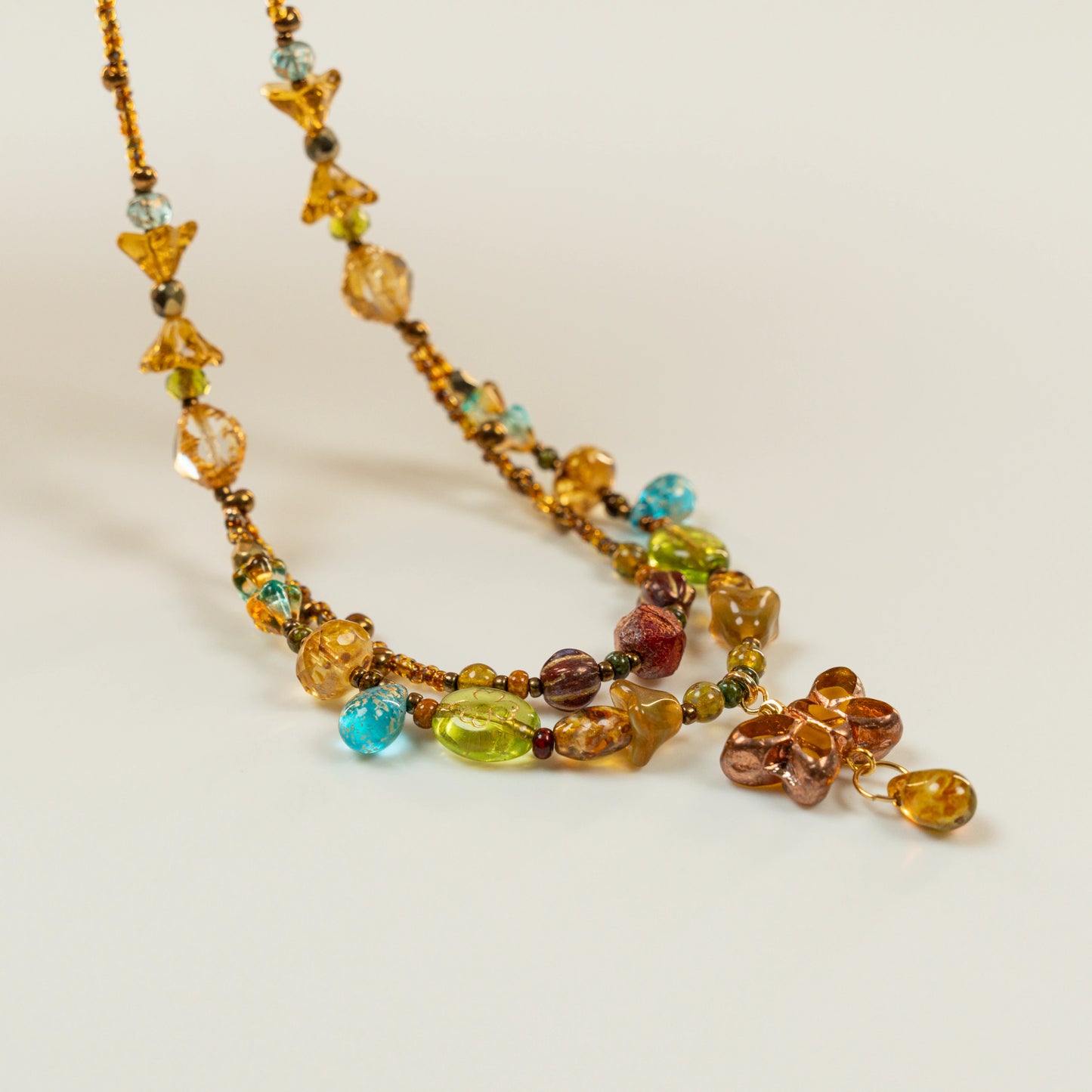 Dubbele kralenketting met amberkleurige vlindervormige