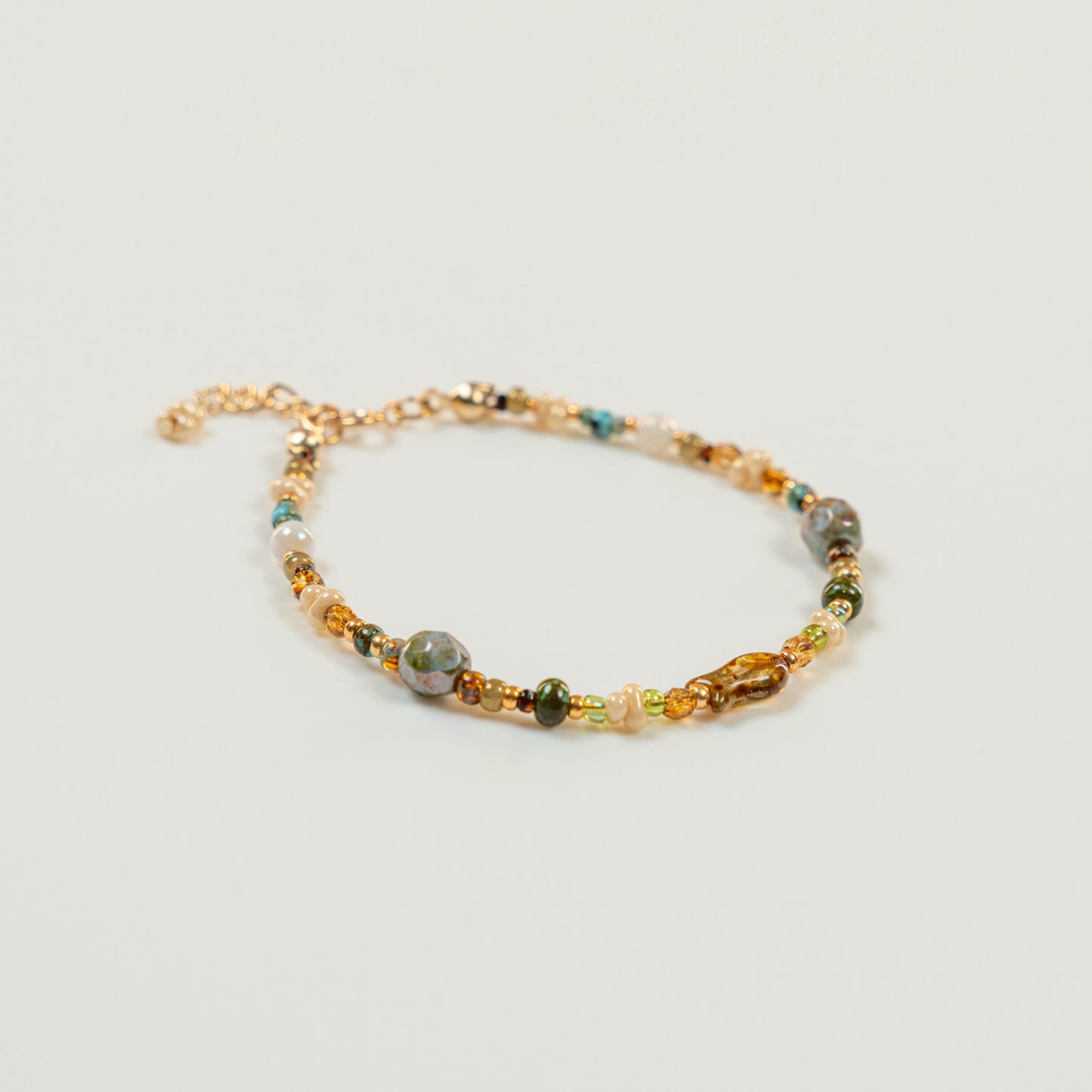 Kralenarmband met visvormige hoofdkraal en parelmoer