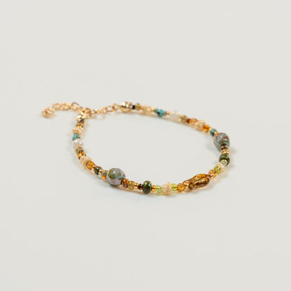 Kralenarmband met visvormige hoofdkraal en parelmoer