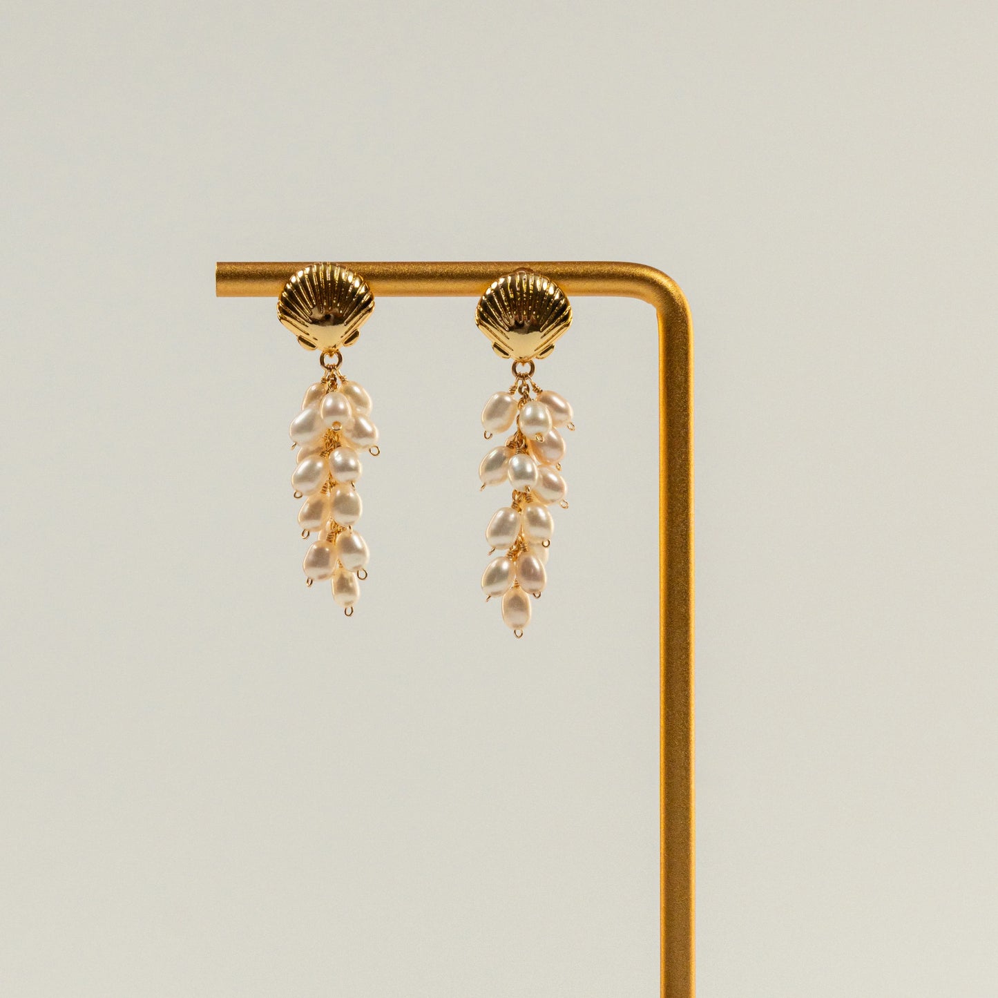 Parel oorbellen met schelpvormige hanger en draadwikkeldesign