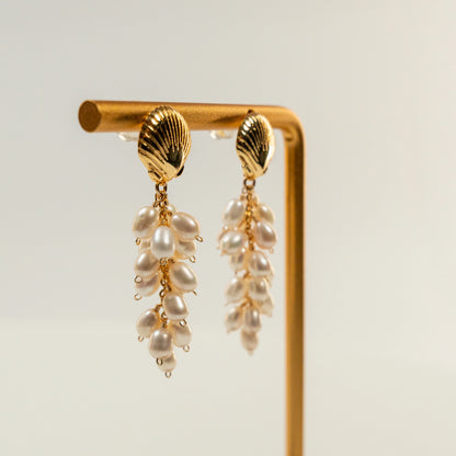 Parel oorbellen met schelpvormige hanger en draadwikkeldesign