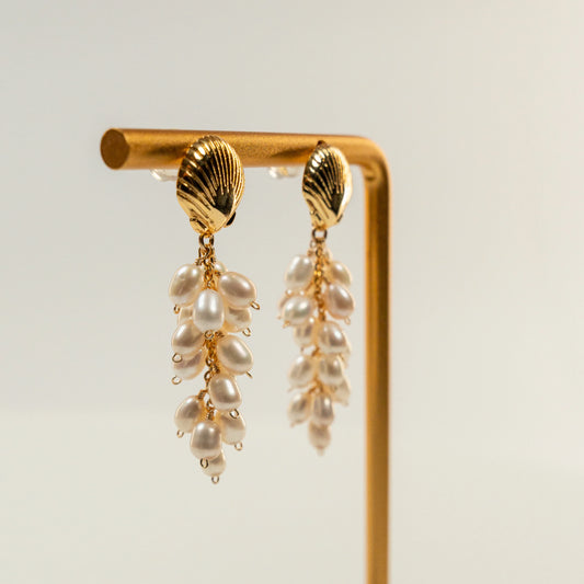 Parel oorbellen met schelpvormige hanger en draadwikkeldesign